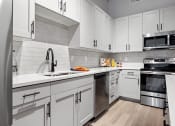Thumbnail 23 of 33 - a kitchen with white cabinets and stainless steel appliances at The Residences at Tesson Ridge, Saint Louis, Missouri