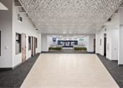 Thumbnail 17 of 33 - an empty hallway in a building with white walls and tiled floors at The Residences at Tesson Ridge, Saint Louis, 63128