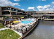 Thumbnail 103 of 112 - A pool surrounded by a fence and umbrellas. at The Residences at Tesson Ridge Apartments, Saint Louis, MO, 63128