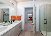 Thumbnail 41 of 112 - A bathroom with a walk-in shower and a vanity with two sinks. at The Residences at Tesson Ridge Apartments, Saint Louis