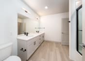 Thumbnail 33 of 112 - A white bathroom with a wooden floor and a white toilet. at The Residences at Tesson Ridge Apartments, Saint Louis, Missouri