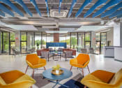 Thumbnail 33 of 33 - a lobby with yellow chairs and tables and a blue pillar