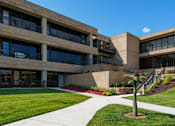 Thumbnail 69 of 112 - A building with a palm tree in front at The Residences at Tesson Ridge Apartments, Saint Louis