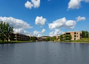 Thumbnail 93 of 112 - A large body of water with a building in the background and trees on the left. at The Residences at Tesson Ridge Apartments, Saint Louis