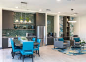 Thumbnail 50 of 54 - a living room and kitchen with blue chairs and a table