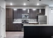 Thumbnail 47 of 54 - a modern kitchen with stainless steel appliances and dark wood cabinets