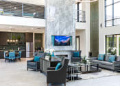 Thumbnail 46 of 54 - a lobby with couches chairs and tables and a fireplace