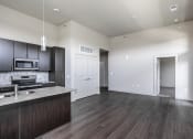 Thumbnail 43 of 54 - an empty kitchen and living room with wood flooring and white walls
