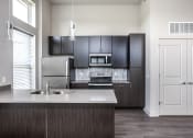 Thumbnail 42 of 54 - a kitchen with stainless steel appliances and black cabinets