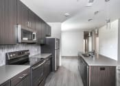 Thumbnail 39 of 54 - an empty kitchen with stainless steel appliances and wooden cabinets