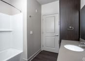 Thumbnail 37 of 54 - a small bathroom with a toilet and a shower in a room with a wooden floor