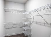 Thumbnail 35 of 54 - the walk in closet of a studio apartment with wire shelving