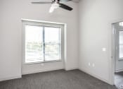 Thumbnail 33 of 54 - an empty bedroom with a large window and a ceiling fan