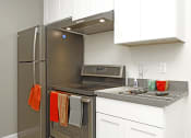 Thumbnail 12 of 31 - a kitchen with white cabinets and stainless steel appliances