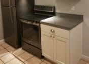 Thumbnail 13 of 31 - a kitchen with white cabinets and black appliances