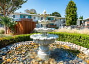 Thumbnail 2 of 31 - a fountain in front of an apartment complex