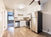 Thumbnail 26 of 37 - a kitchen with white cabinets and a stainless steel refrigerator