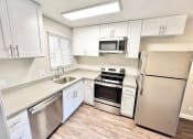 Thumbnail 11 of 37 - a kitchen with white cabinets and stainless steel appliances