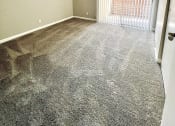Thumbnail 14 of 37 - a bedroom with a large window and a carpeted floor