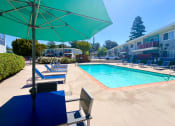 Thumbnail 30 of 31 - the pool area of a hotel with chairs and umbrellas