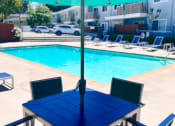 Thumbnail 31 of 31 - a dining table with an umbrella next to a swimming pool