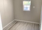 Thumbnail 21 of 37 - a empty room with wooden floors and a window