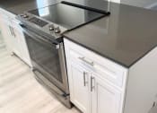 Thumbnail 25 of 37 - a kitchen with a stove and a counter top