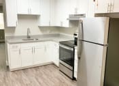 Thumbnail 36 of 37 - a white kitchen with a refrigerator and a stove