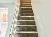 Thumbnail 35 of 37 - a staircase with a railing and carpeted stairs
