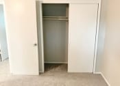 Thumbnail 28 of 37 - an empty bedroom with a closet and a carpeted floor