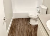 Thumbnail 32 of 37 - a white bathroom with a toilet and a tub and a sink