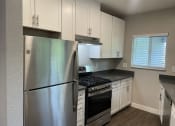 Thumbnail 27 of 31 - a kitchen with white cabinets and stainless steel appliances