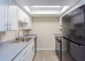 Thumbnail 4 of 17 - a kitchen with white cabinets and black appliances