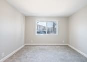 Thumbnail 8 of 31 - a bedroom with a large window and a carpeted floor