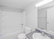 Thumbnail 31 of 31 - A white bathroom with a toilet, sink, and bathtub.