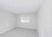 Thumbnail 28 of 31 - A white room with a window and carpeted floor.