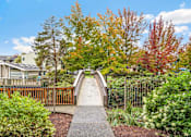 Thumbnail 22 of 27 - A bridge in a residential area with trees in autumn colors.