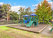 Thumbnail 27 of 27 - A playground with a green slide and a blue canopy.