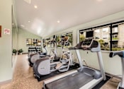 Thumbnail 19 of 27 - A gym with treadmills and exercise bikes.