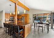 Thumbnail 3 of 27 - A kitchen with a long island and chairs.
