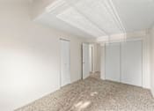 Thumbnail 13 of 27 - A white room with carpeted floor and white walls.