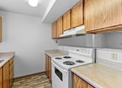 Thumbnail 20 of 27 - A kitchen with a white stove and wooden cabinets.