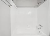 Thumbnail 26 of 40 - A white bathroom with a tub and shower.