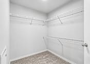 Thumbnail 25 of 28 - Empty white closet with shelves and carpeted floor.
