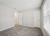 Thumbnail 27 of 40 - A room with a carpeted floor and two white doors.