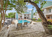 Thumbnail 21 of 25 - A pool surrounded by chairs and trees.