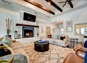 Thumbnail 10 of 28 - Northwest San Antonio, TX, Apartments - Azul Apartment Homes - Resident Lounge With Sofas, Stone Fireplace, Blue Tile Surround, Exposed Wood Beams, Ceiling Fan, And Patterned Area Rug.