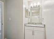 Thumbnail 30 of 40 - A bathroom with a sink, mirror, and cabinets.