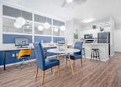 Thumbnail 2 of 25 - A modern kitchen and dining area with blue chairs and a white table.