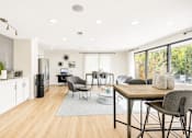 Thumbnail 3 of 40 - A modern kitchen with a dining table and chairs.